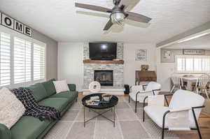 Living room featuring a real hardwood floors and a cozy brick fireplace.