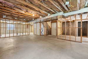 Basement - Far Door on Concrete Wall Shows Walk-Out Leading to Upstairs Garage