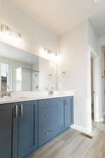 Bathroom with vanity, toilet, a shower with door, and hardwood / wood-style floors