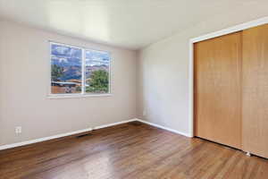 Unfurnished bedroom with a closet and hardwood / wood-style floors