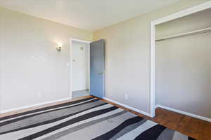 Unfurnished bedroom featuring hardwood / wood-style floors and a closet