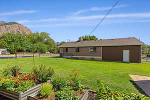 Back of house featuring a lawn and a mountain view