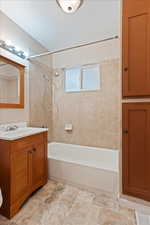 Bathroom featuring tile patterned flooring, tiled shower / bath, and vanity