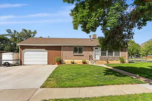 Single story home with a garage and a front lawn