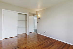 Unfurnished bedroom with hardwood / wood-style flooring and a closet