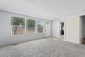 Spare room with a textured ceiling and carpet