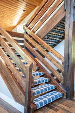 Stairs featuring lofted ceiling and hardwood / wood-style floors