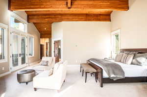 Carpeted bedroom featuring wood ceiling, multiple windows, beamed ceiling, and french doors