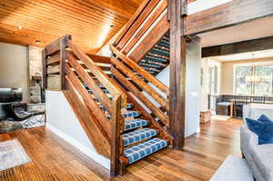 Stairway with wooden ceiling and hardwood / wood-style flooring