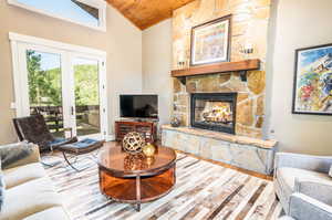 Living room with a fireplace, french doors, hardwood / wood-style floors, and wood ceiling