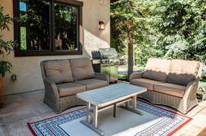 View of patio with an outdoor hangout area and a grill