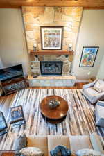 Living room featuring hardwood / wood-style floors and a stone fireplace