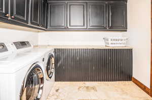 Laundry area with washer and clothes dryer, light tile patterned floors, and cabinets