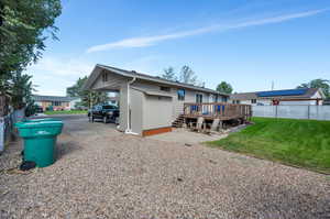 Back of property featuring a deck, and a lawn