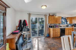 Kitchen featuring sink, dark tile patterned flooring, and dishwasher