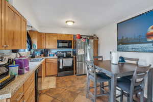 Kitchen with sink, tile patterned flooring, and black appliances