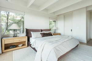 Bedroom with beam ceiling and hardwood / wood-style flooring