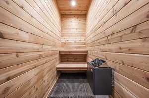 View of sauna with tile patterned flooring and wood walls