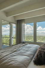 Unfurnished bedroom featuring beam ceiling and access to outside