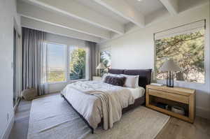 Bedroom with beam ceiling and hardwood / wood-style flooring