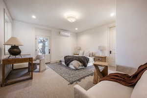 Bedroom with an AC wall unit and carpet floors