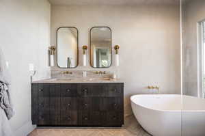 Bathroom featuring tile patterned flooring, a bathtub, and vanity