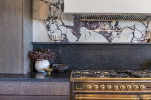 Interior details featuring double oven range, dark brown cabinetry, and backsplash