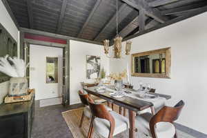 Dining room featuring an inviting chandelier, wooden ceiling, and lofted ceiling with beams