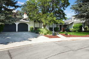 View of property hidden behind natural elements featuring a front yard