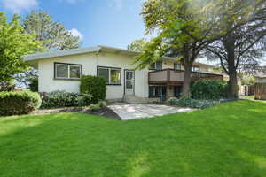 Rear view of house featuring a yard and a deck