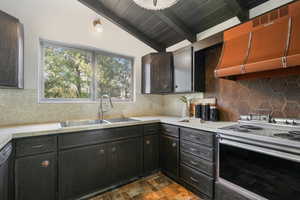 Kitchen featuring decorative backsplash, sink, white range with electric stovetop, wood ceiling, and custom exhaust hood