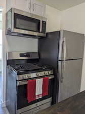 Kitchen featuring white cabinets, wood-type flooring, and stainless steel appliances