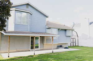 Rear view of house with a storage shed, a patio, and a lawn