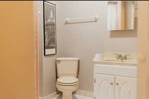 Bathroom featuring tile patterned flooring, vanity, and toilet