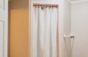 Details with curtained shower and crown molding