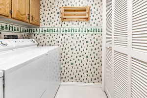 Laundry room with washing machine and clothes dryer and cabinets