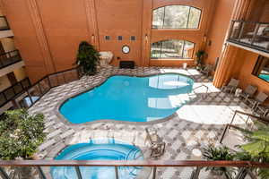 View of pool with an indoor in ground hot tub and a patio