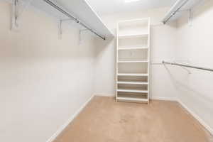 Spacious closet with light carpet off of Primary Owners Bedroom