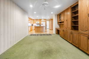 Family room with built in wall units with view of Kitchen.