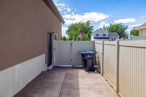 Fully fenced yard with a ga, ring camera doorbell by the side garage door.