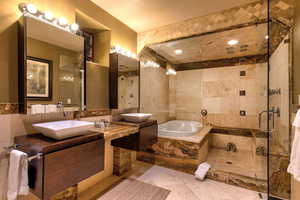 Bathroom with vanity, tile patterned floors, tile walls, a textured ceiling, and plus walk in shower