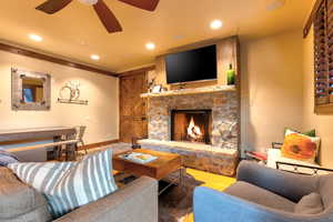 Living room with ceiling fan, a fireplace, and hardwood / wood-style floors