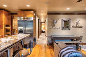 Interior space featuring light wood-type flooring, appliances with stainless steel finishes, and light stone countertops