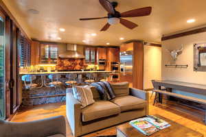 Living room featuring light hardwood / wood-style floors, ceiling fan, and a textured ceiling