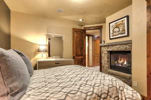 Bedroom with a fireplace and a textured ceiling