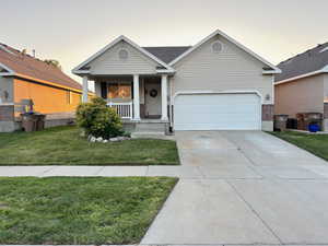 View of front of house featuring a lawn, a garage, and a porch