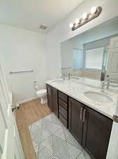 Bathroom with toilet, vanity, and hardwood / wood-style flooring