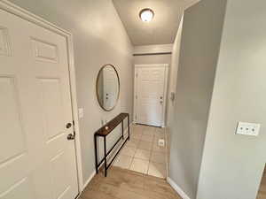 Interior space with a textured ceiling and light hardwood / wood-style floors