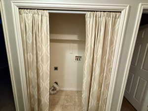 Clothes washing area featuring washer hookup, light tile patterned floors, and hookup for an electric dryer