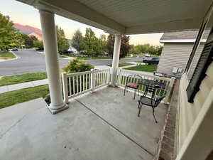 Patio terrace at dusk with a mountain view and a porch